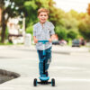 little boy having great time outside in summer season with his scooter